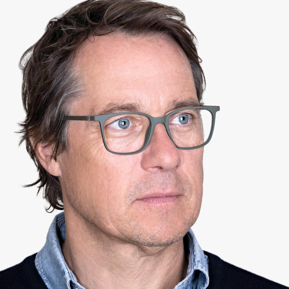 Person wearing Fyn Dark Army glasses with rectangular frame