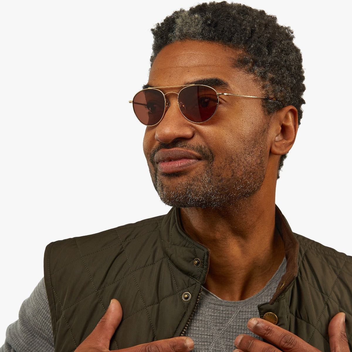 Person wearing Göteborg Gold round sunglasses with gold frame