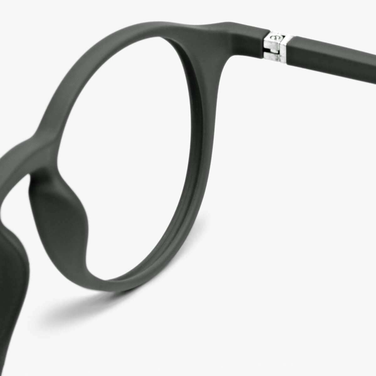 Close-up of black round frame glasses with silver hinge detail