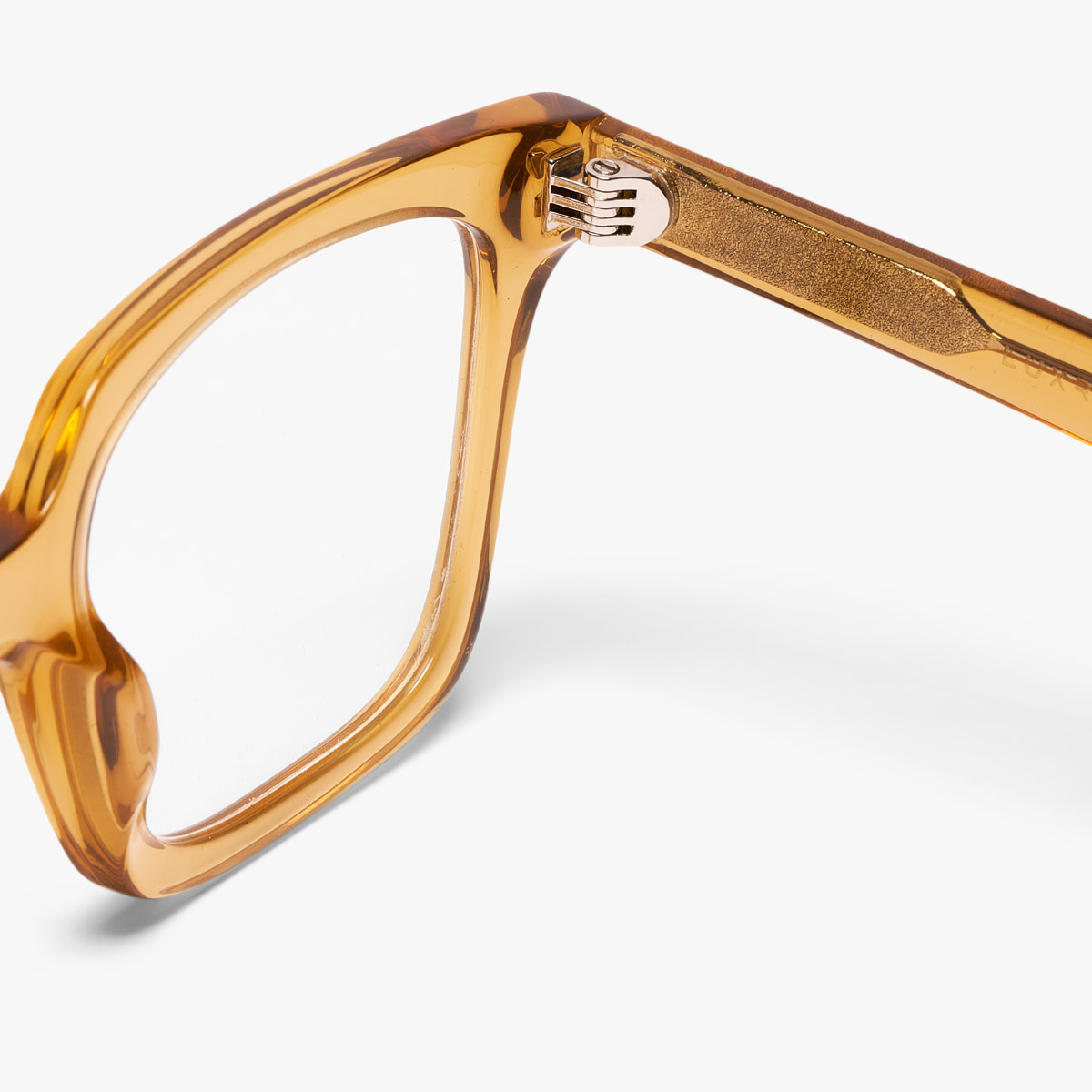Close-up of caramel crystal eyewear frame and gold hinge